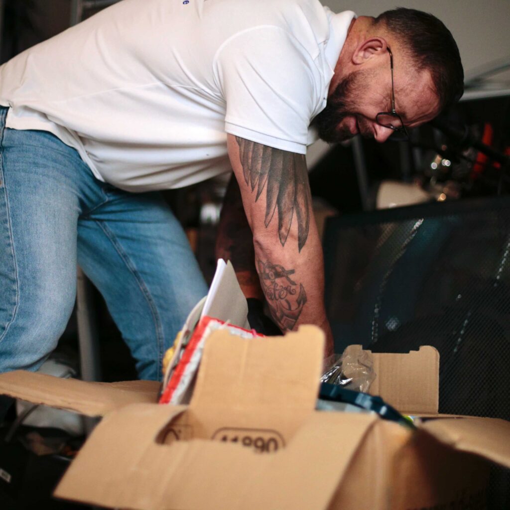 Person bei einer Entr&uuml;mpelung in Aachen die Sachen in Kartons verpackt