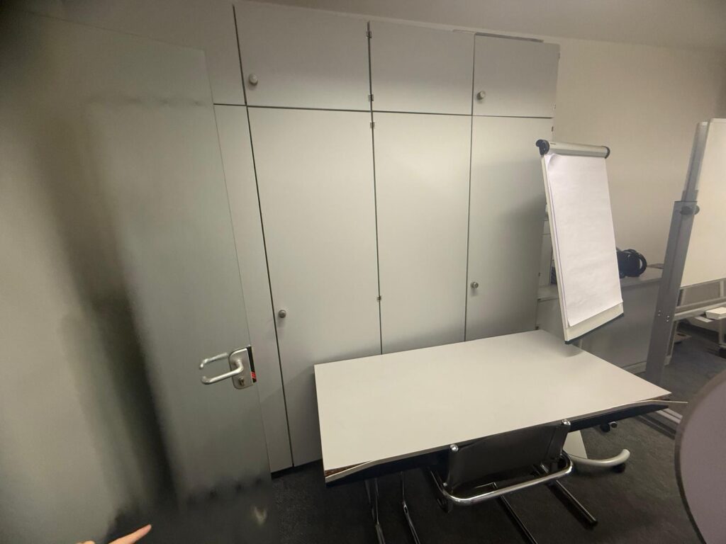 Leerer Besprechungsraum mit Tisch und Schr&auml;nken bei einer Gewerbeentr&uuml;mpelung