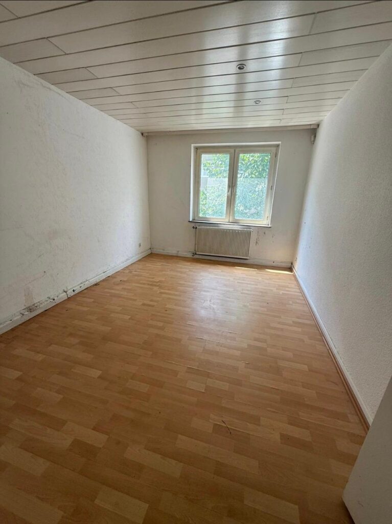 Leerer Raum mit Holzfu&szlig;boden einer Messientr&uuml;mpelung